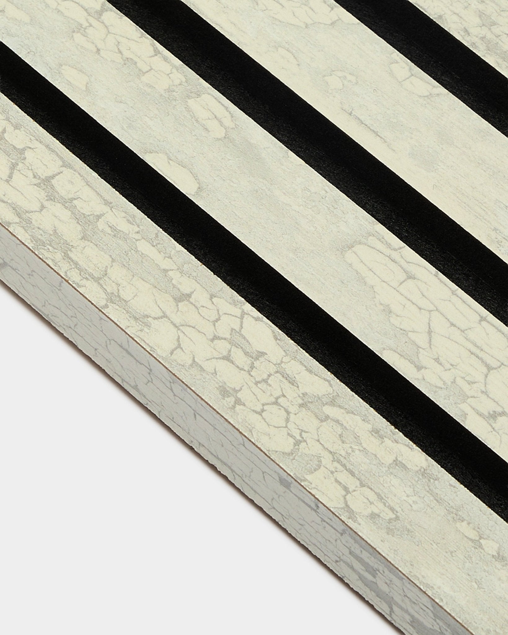 Close-up of WoodUpp Akupanel End Lamella in Oxide White (2.2 cm) with three diagonal black stripes on an MDF acoustic panel frame.