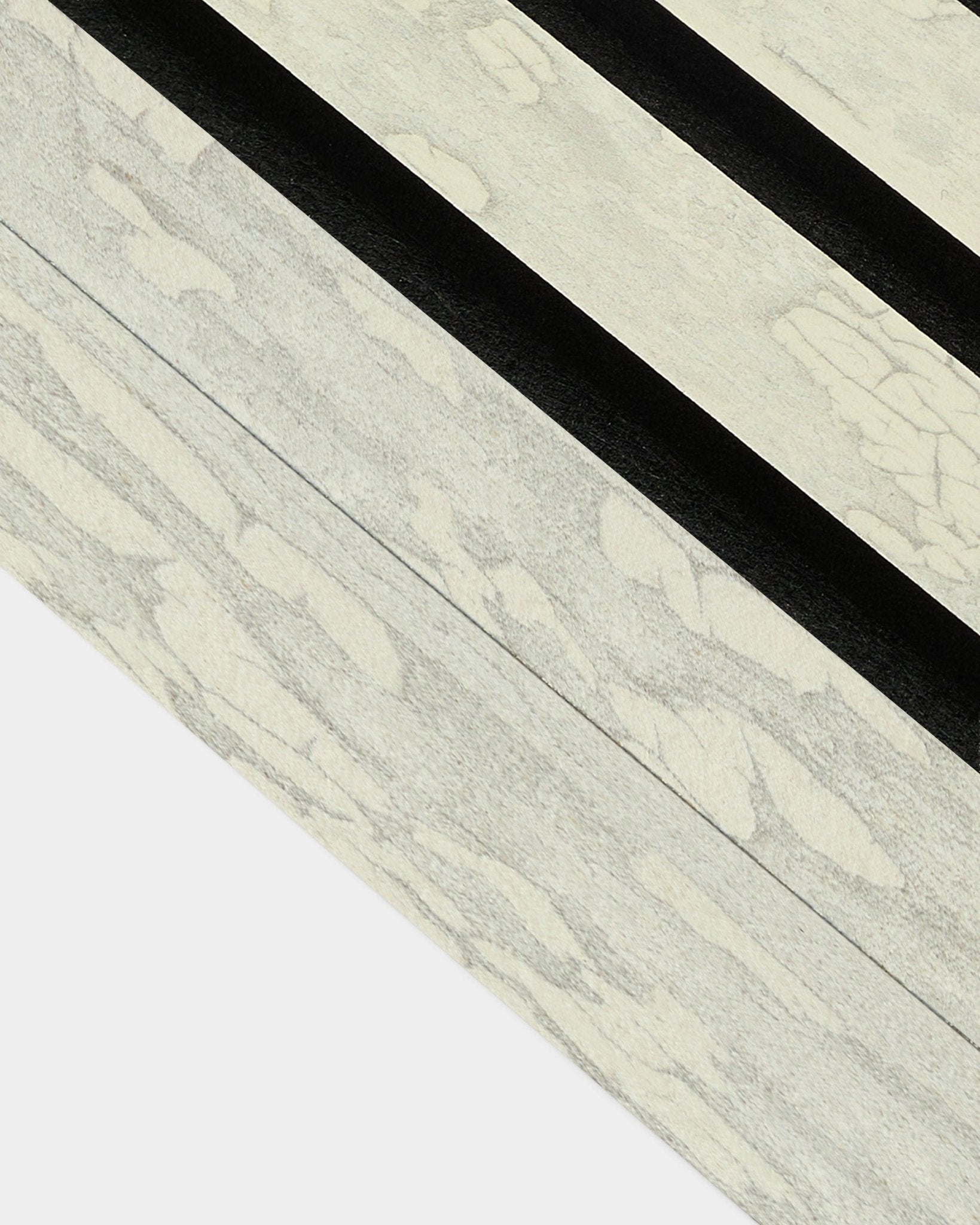 Close-up of Oxide White End Lamella (6.7 cm) by WoodUpp for Akupanel acoustic panel installation, featuring bold black diagonal patterns on a Nordic design.