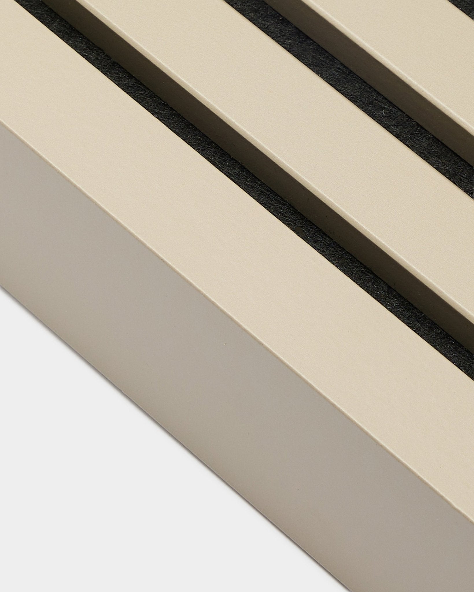 Close-up of WoodUpp End Lamella in Stone finish, 6.7 cm wide—installation accessory for MDF frames or Akupanel acoustic panels. Beige panel slats with black gaps.