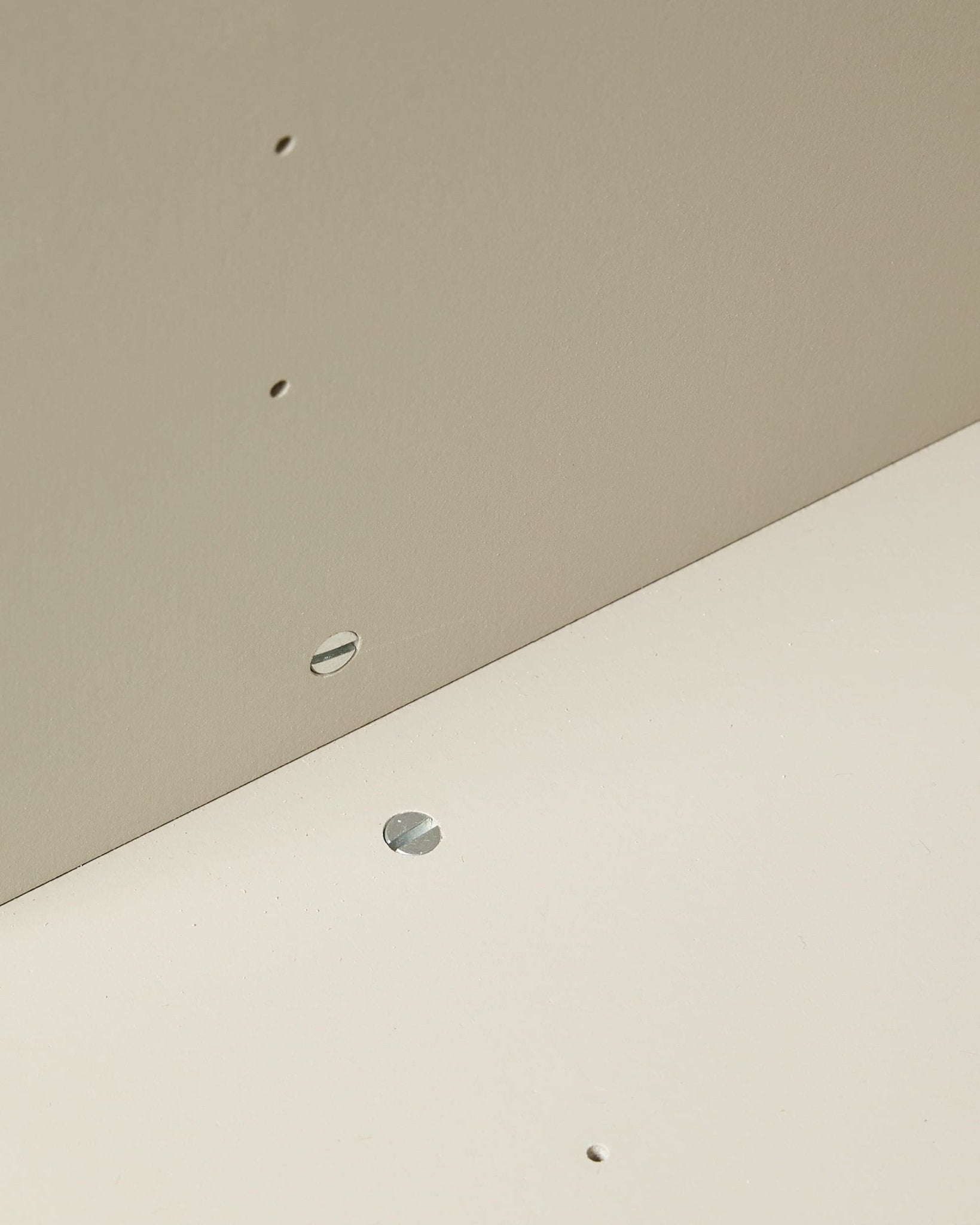 Close-up of two beige WoodUpp Arka Open Cabinets joined at a right angle, featuring small holes and a visible metal fastener.