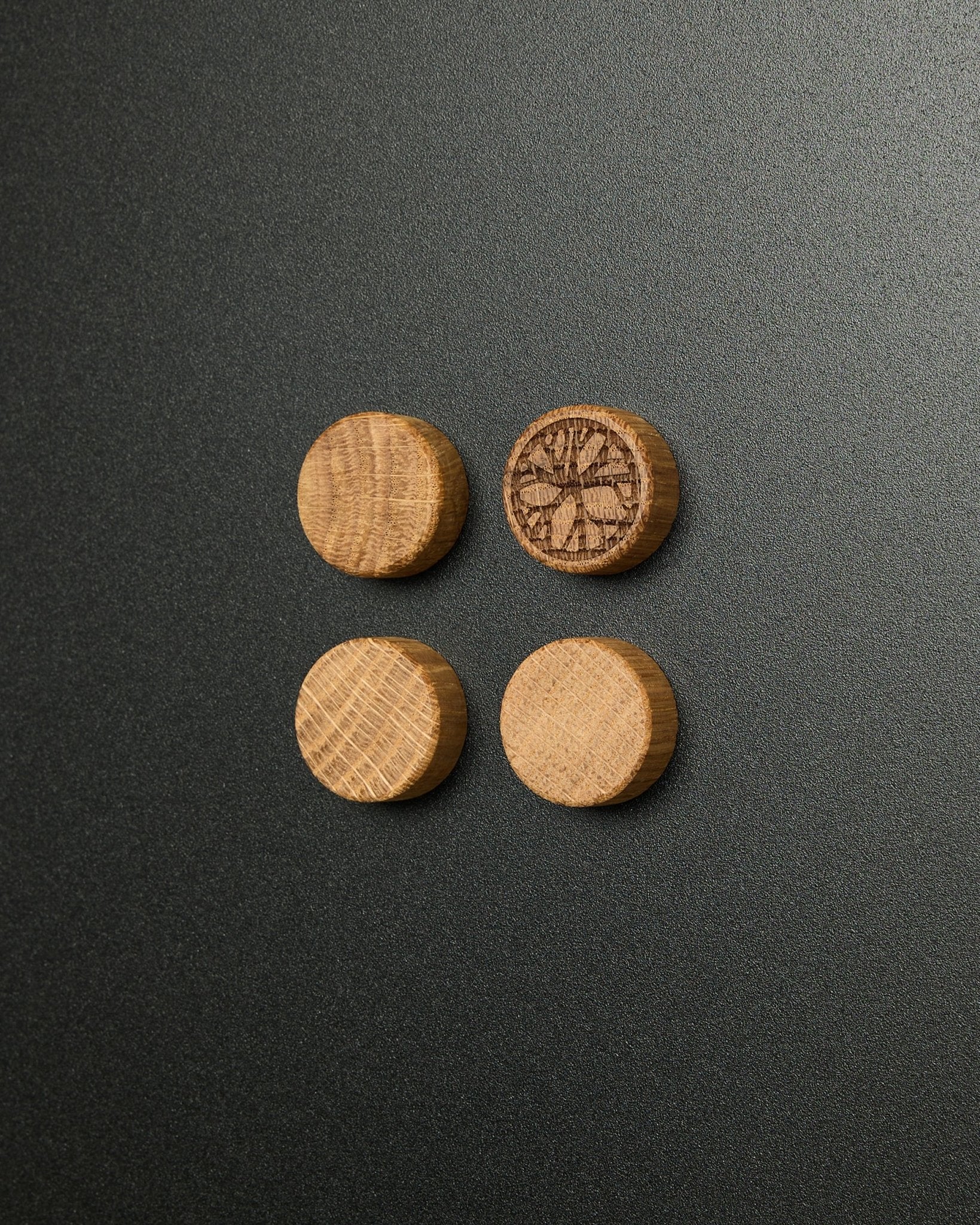 Set of four solid natural oak magnets by WoodUpp, one featuring a carved citrus slice design, designed for use with the Norr Magnetic Board acoustic panel.