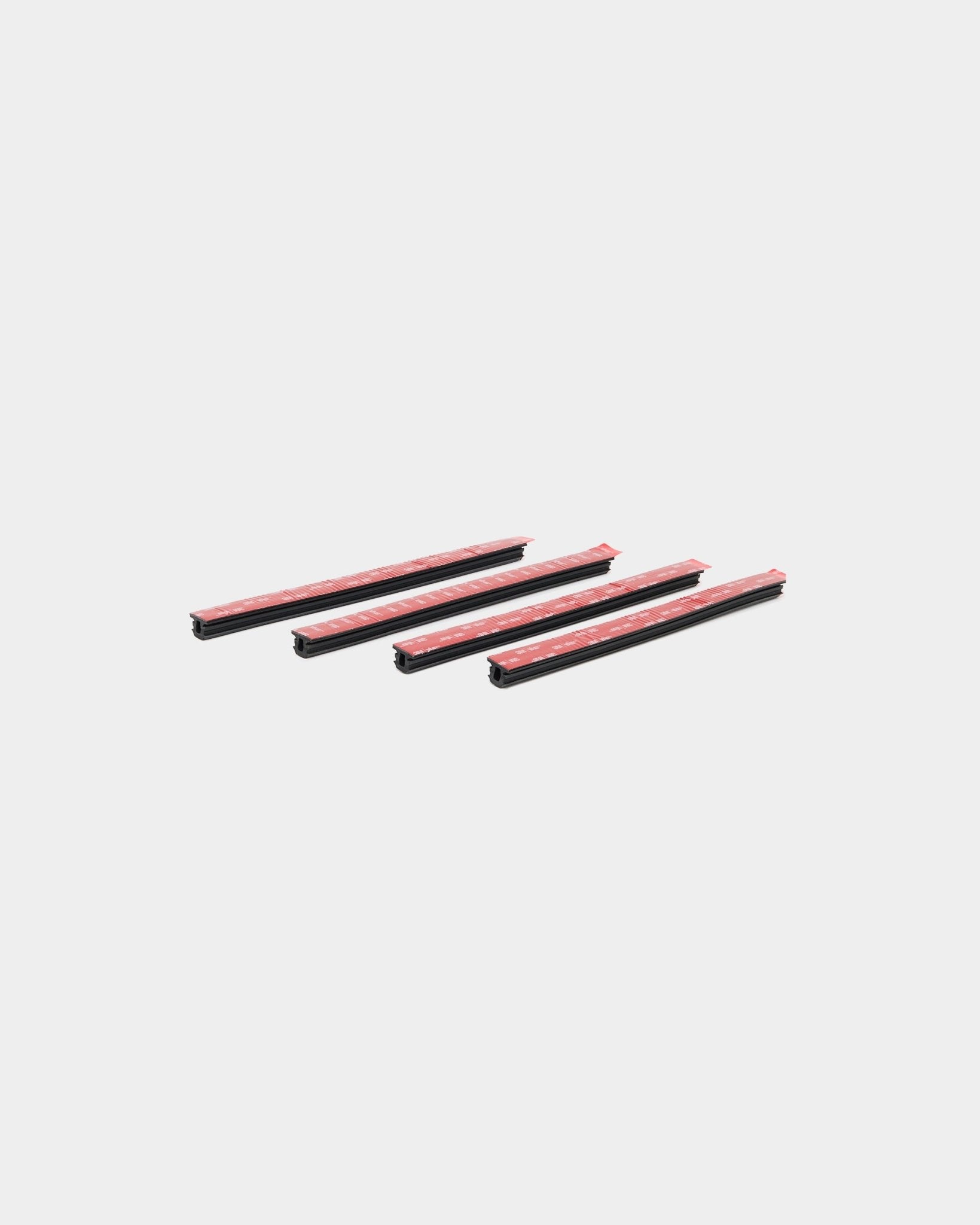 Four black Dupps Pop-on Profile car door edge guards, WoodUpp 4-piece set, arranged diagonally on a white background.