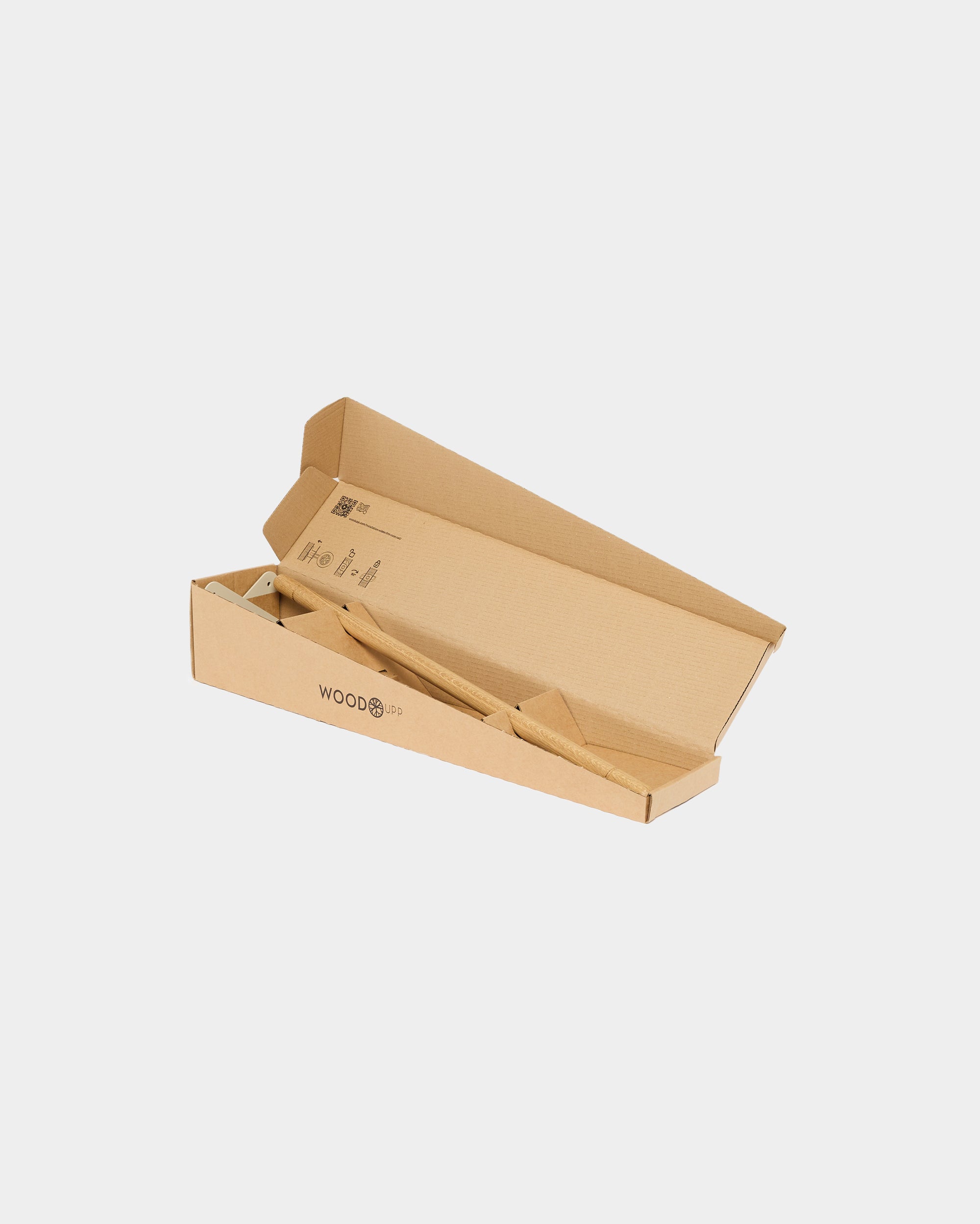 A flat, partially opened brown cardboard box with WOOD printed on the side, designed for WoodUpp acoustic panels, rests on a plain white background.