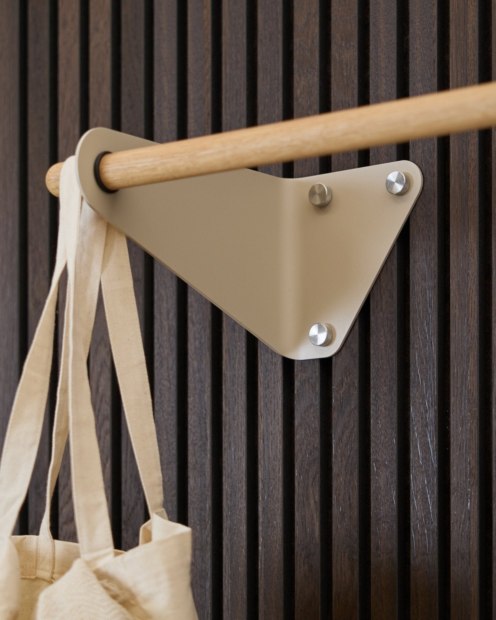 Beige WoodUpp Linn Coat Rail (115.9 cm) mounted on Akupanel acoustic panel, holding a cream fabric bag on the left side.