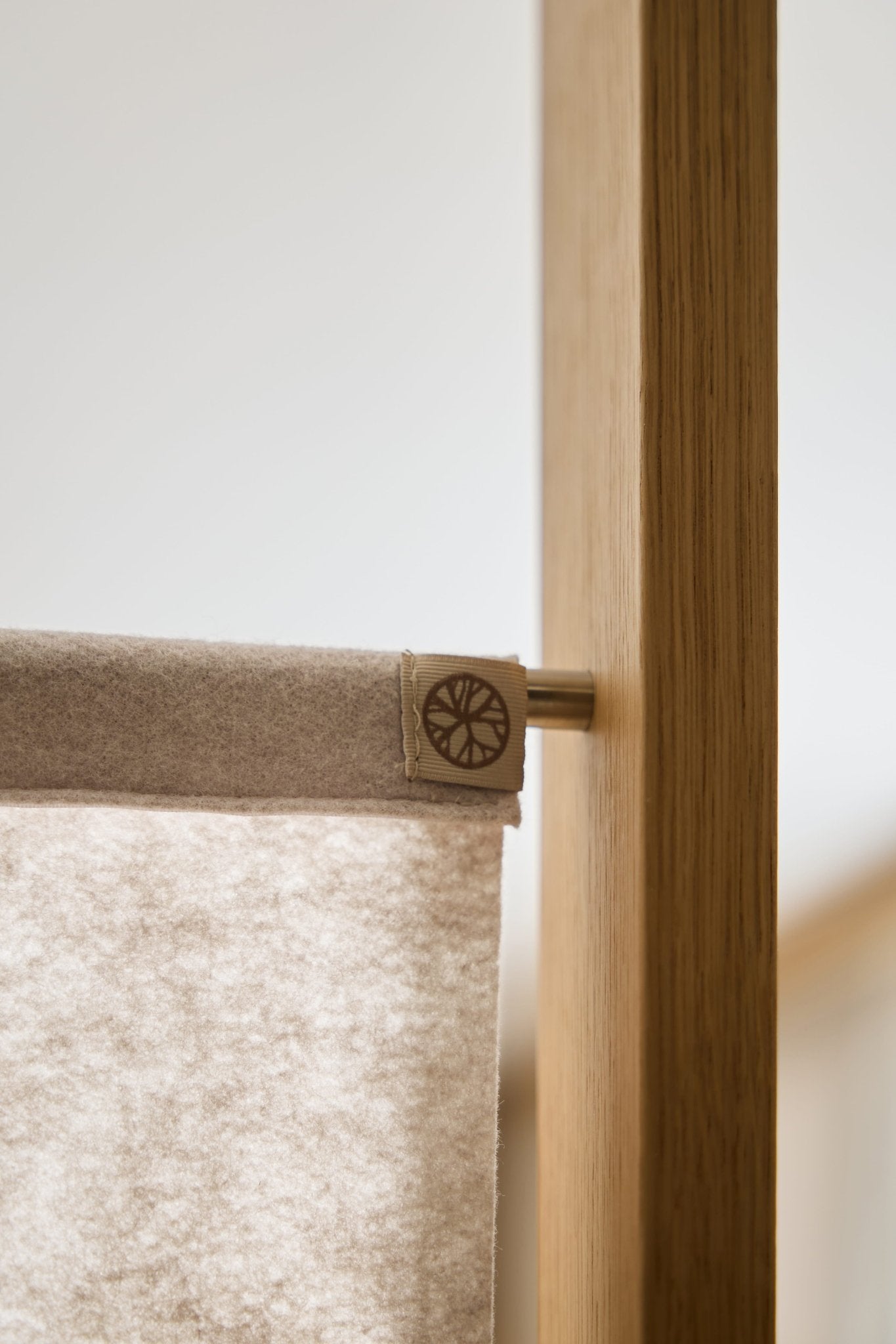 Close-up of the Vigg Felt Sheet (58x241 cm, Light Beige) by WoodUpp, mounted on a metal rod and wood frame as a modular room divider panel.