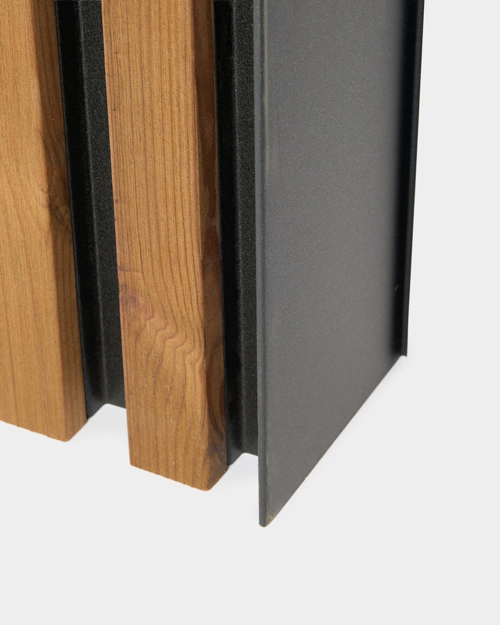 Close-up of WoodUpp Aluwood facade panel, 240 cm, featuring vertical wooden slats and a dark powder-coated aluminum profile for outdoor installation.
