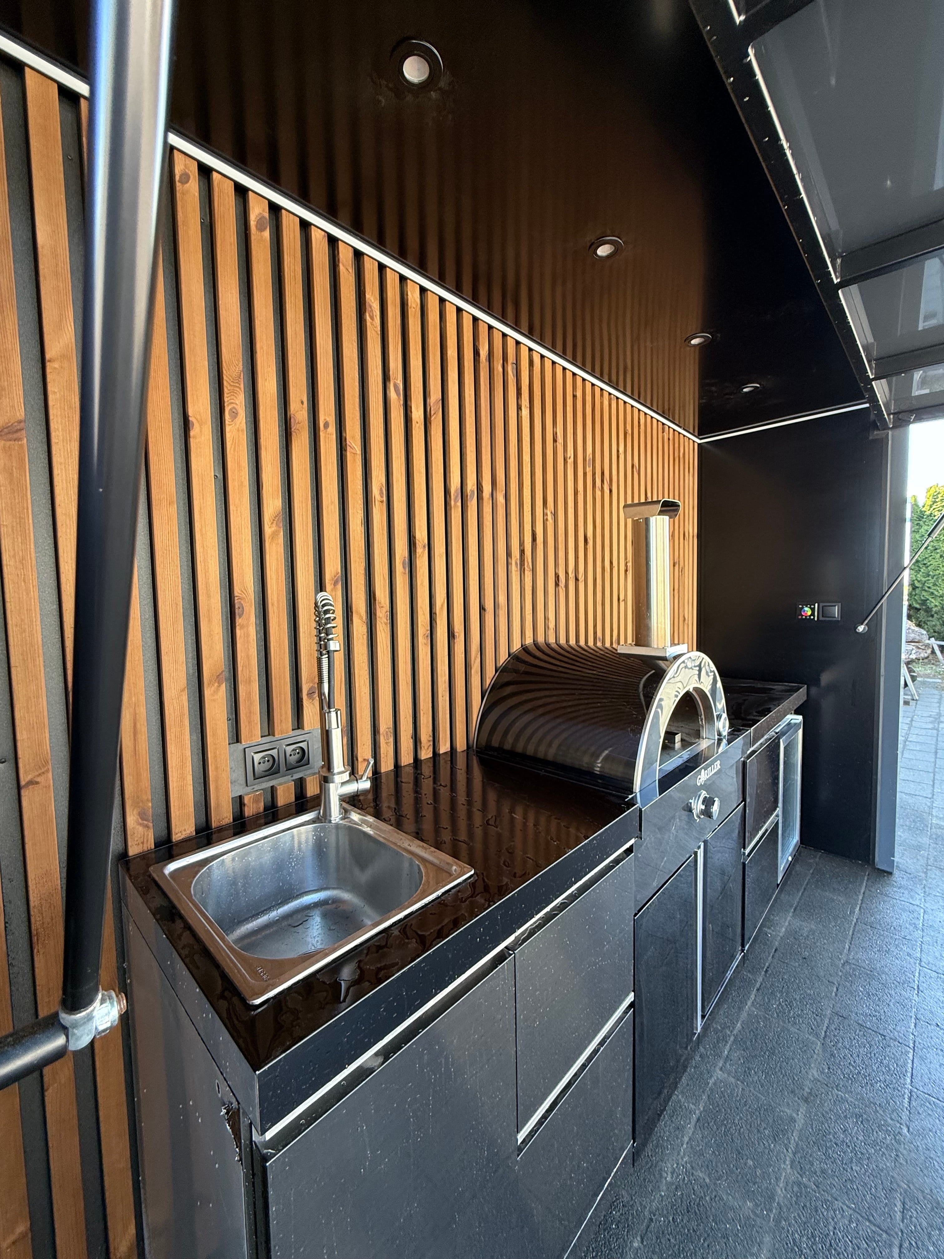 Akupanel wood slat acoustic wall panels with black backing in an outdoor kitchen setting