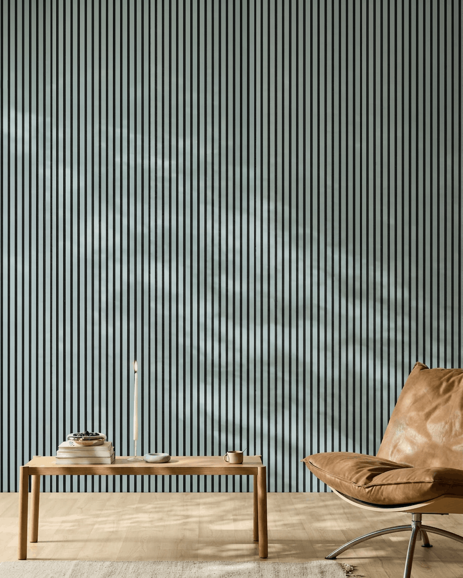 Minimalist room featuring a wooden bench, books, and a brown leather chair in front of a WoodUpp Akupanel acoustic panel in Cloud color with black felt.