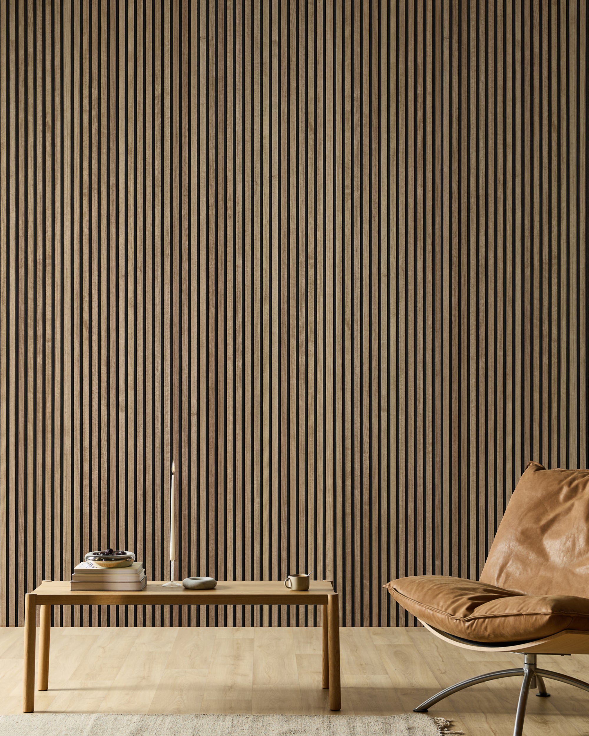 Minimalist room with a leather chair, wooden bench, books, candle, and a modern Akupanel acoustic slat wood accent wall in neutral tones.