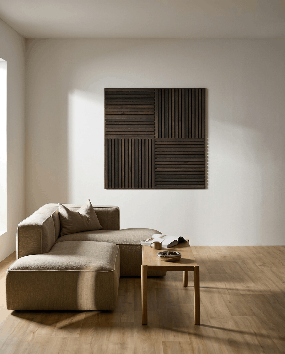 Minimalist living room featuring a beige sectional, wooden coffee table with open book, and WoodUpp Akupixel acoustic panel in Rustic Smoked Oak on a white wall.
